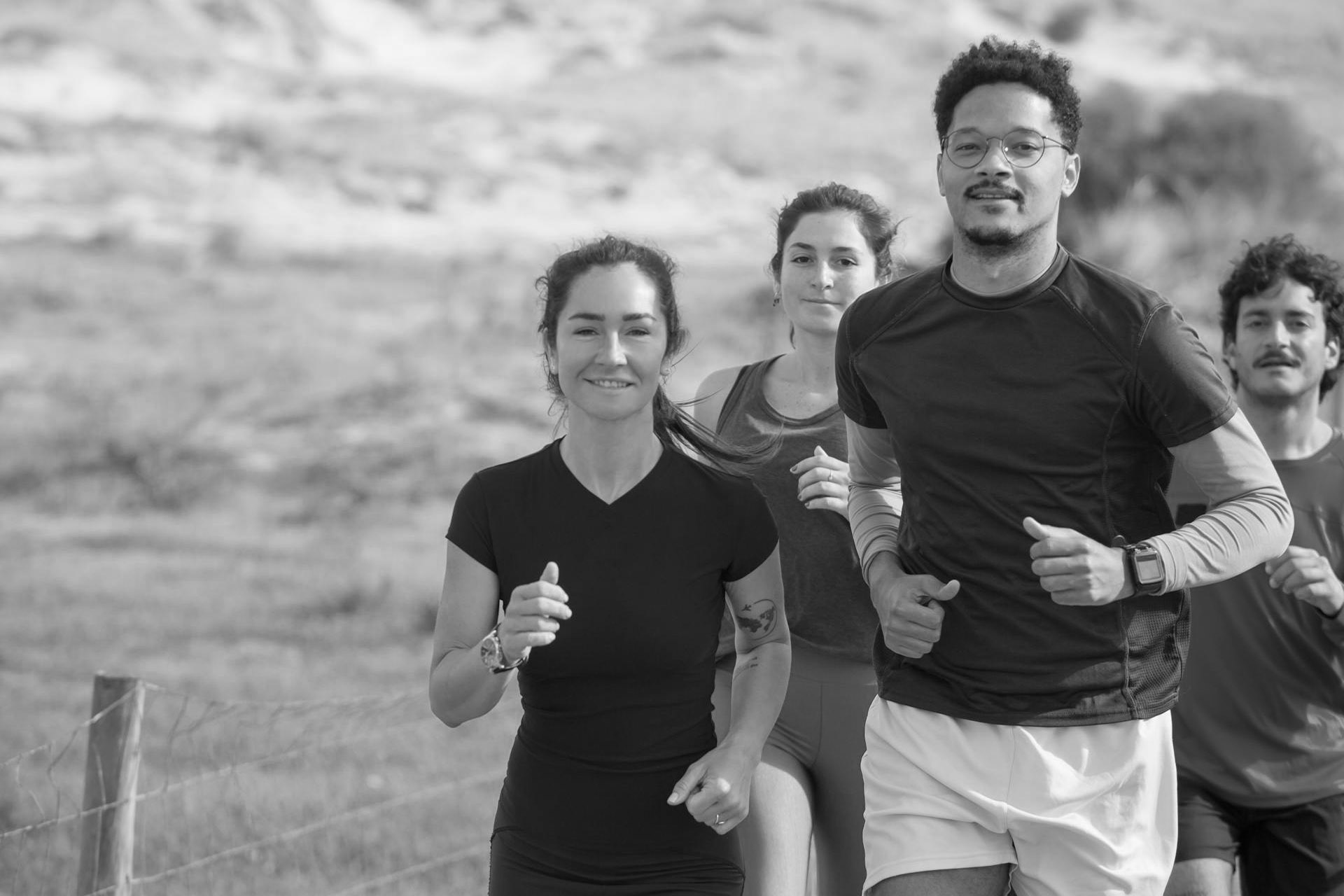 Group of athletes running together outdoors, showcasing teamwork and fitness training.