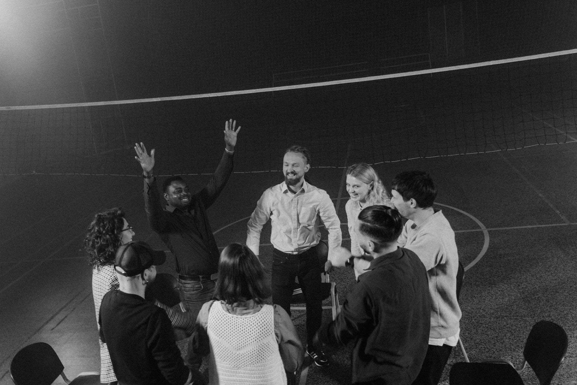 Team celebrating and cheering together on a volleyball court, showing unity and team spirit.